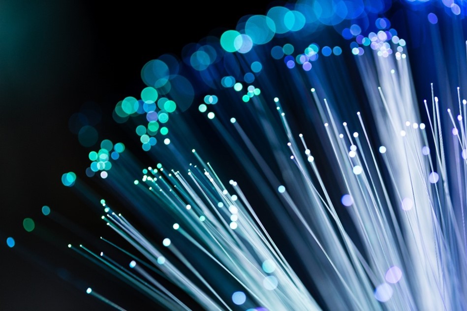 Blue and green illuminated fiber optic strands against a black background